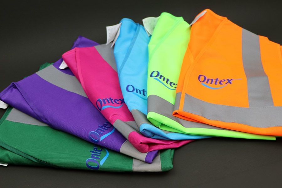 fluohesjes in verschillend kleuren met bedrukking van het logo van Ontex